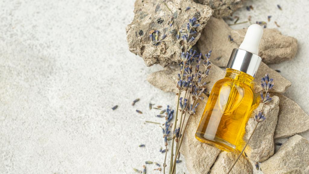 Essential oil and lavender leafs on a rocky floor. 